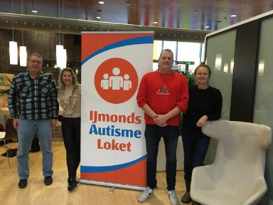 Vrijwilligers van het IJmonds Autisme Loket voor banner in de Bibliotheek